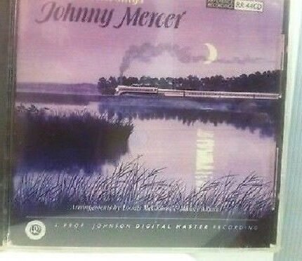 Album cover: purple sunset over a lake, a train crossing a bridge, crescent moon in sky, 'Johnny Mercer' text at top.