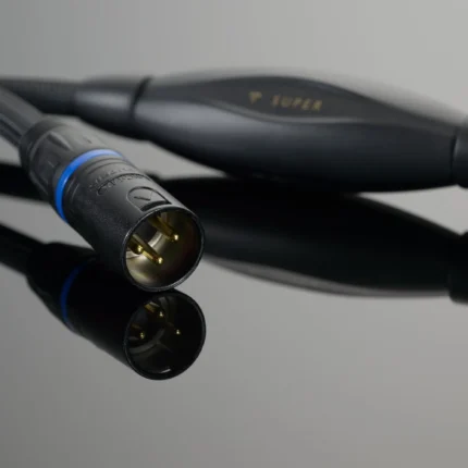 Close-up of a three-pin XLR audio connector with a braided cable on a reflective surface.