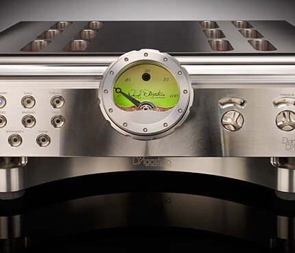 High-end stereo amplifier front panel with large analog dial and multiple knobs and input jacks on brushed metal body.