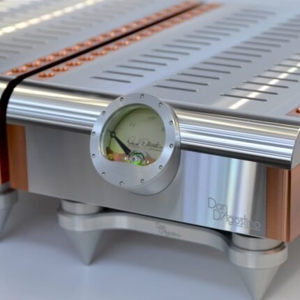 Close-up of a high-end silver audio amplifier with a round gauge dial and copper accent trim.