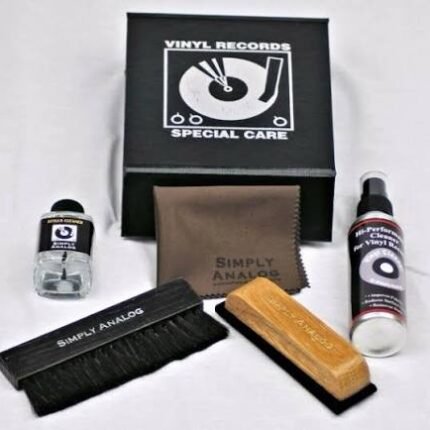 Vinyl record cleaning kit with brush, cloth, wooden cleaning block, and cleaning solution on a white surface.