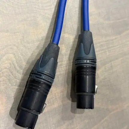 Two blue insulated electrical test probes with black handles resting on a light surface.