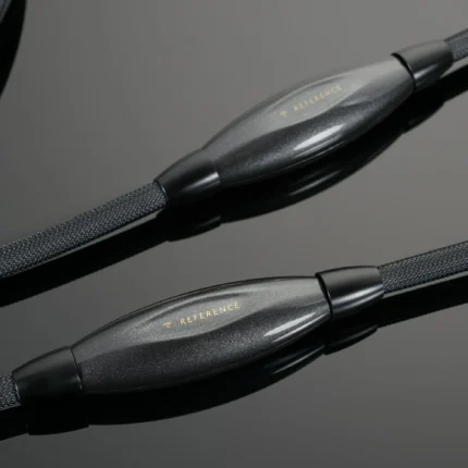 Close-up of braided audio cables with a metallic gray connector labeled 'REFERENCE' on a dark background