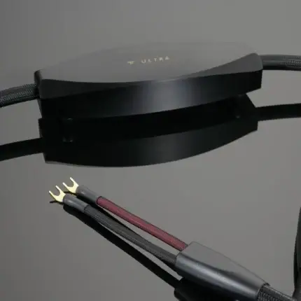 Close-up of a sleek black electronic component with braided cables and gold-plated connectors, labeled ULTRA on top.